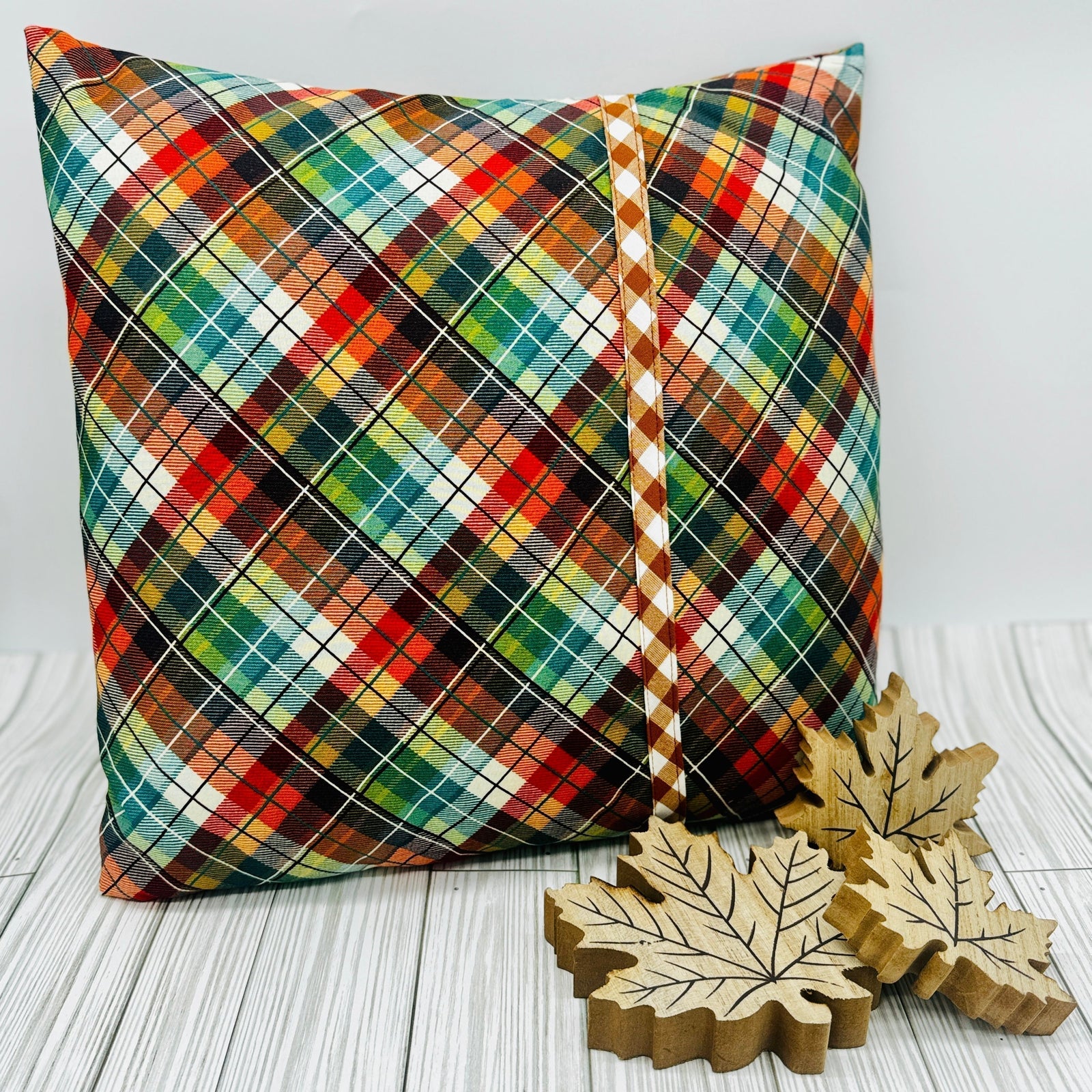 Customizable pillow covers design featuring a colorful plaid pattern and wooden leaf accents