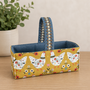 Handmade fabric basket in golden mustard folk art hen print with denim blue lining and woven handle