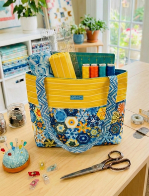 Colorful sewing basket on a table with sewing supplies in a bright room.