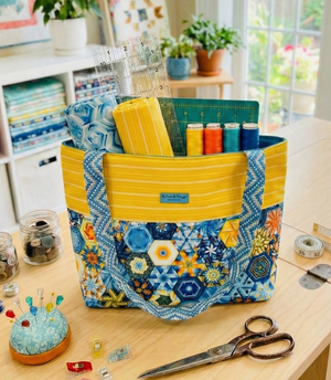 Colorful sewing basket on a table with sewing supplies in a bright room.