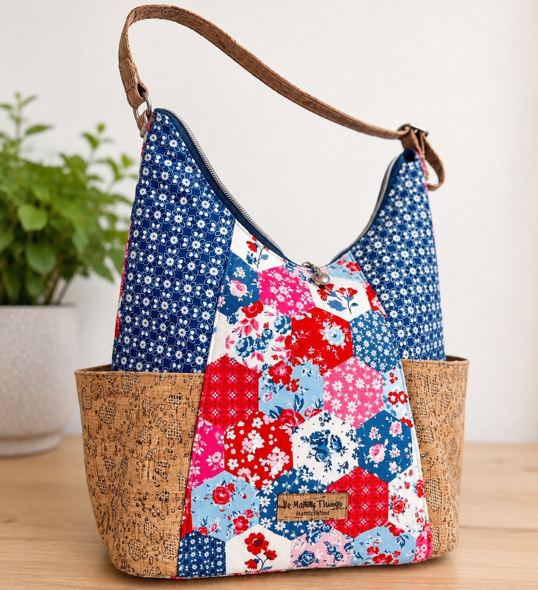 Floral patterned handbag with cork accents on a wooden surface