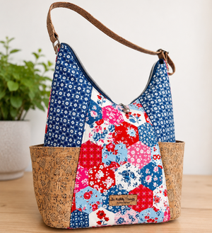 Floral patterned handbag with cork accents on a wooden surface