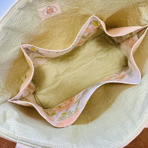 Close-up of a snug bag lining in light green with floral-patterned interior pockets
