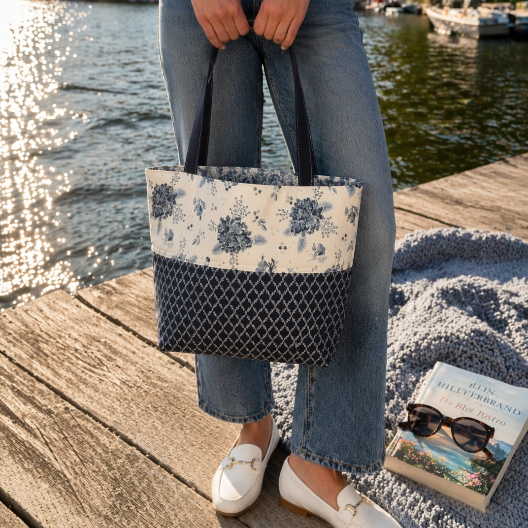 Kathy tote filled with towels against a beach chair with beach accessories
