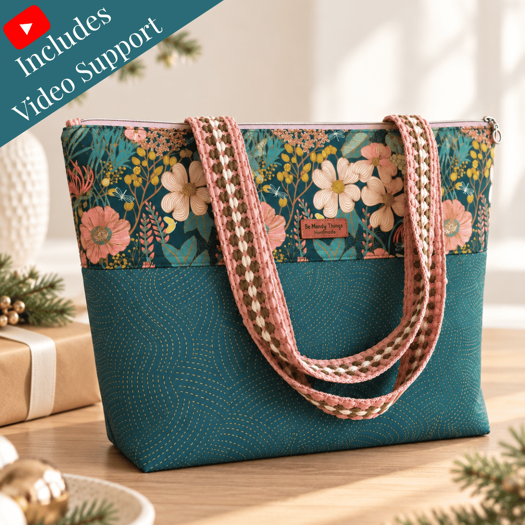 Mae zipper tote in teal with a floral top band and woven handles, beside wrapped holiday gifts, with a Video Support banner