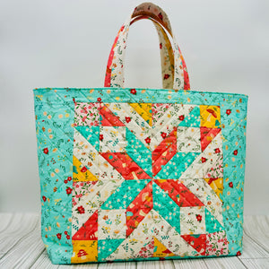 Colorful quilted tote bag featuring a star quilt block pattern with floral fabric