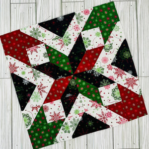 Colorful star quilt block pattern in red green black and white holiday fabrics on wood background