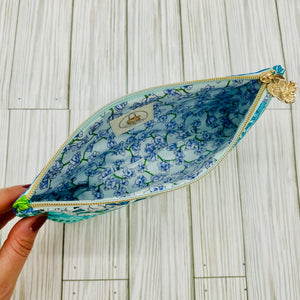 Inside view of a botanical tote and pouch set showing floral lining and zipper closure