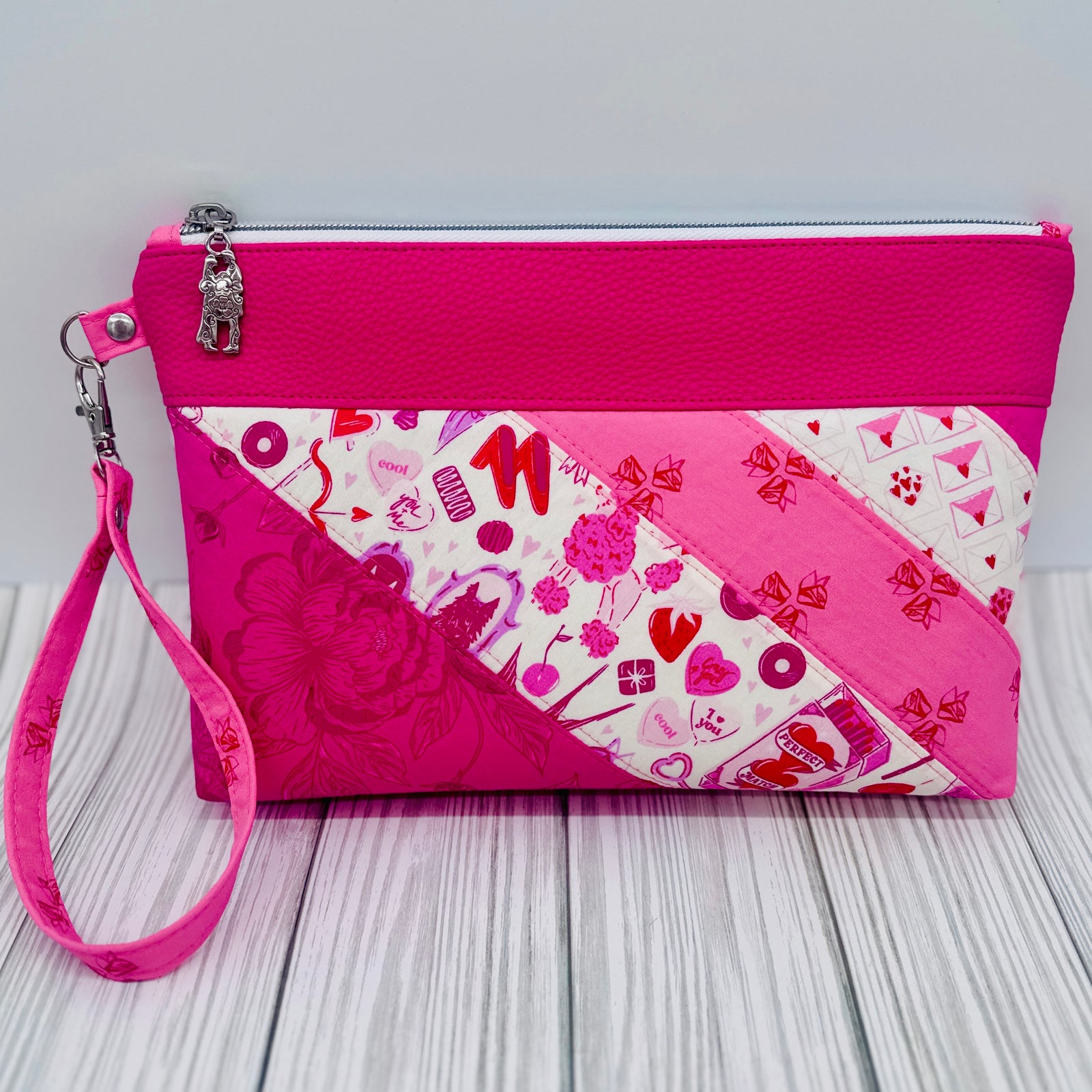 BeMandyThings handcrafted pink handbags with patchwork design and wrist strap on wooden surface