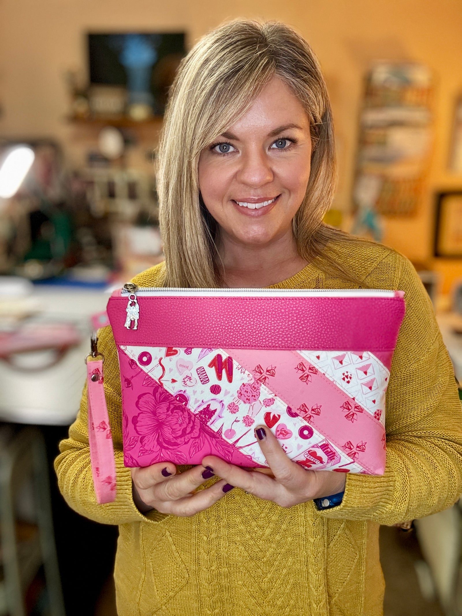 BeMandyThings handcrafted pink handbags featuring patchwork design held by smiling woman in yellow sweater